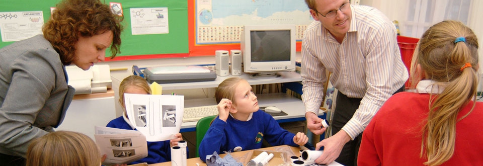 Children and teachers in a classroom making a telescope