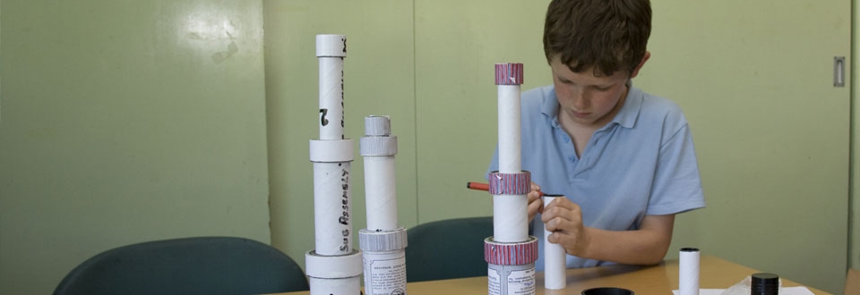 Young boy making a telescope from tubes and lenses