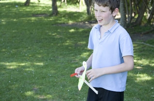 Young boy holding a rubber band powered model helicopter