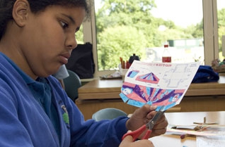 Girl cutting out the paper template for a model plane