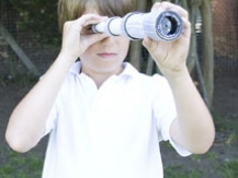 Young boy gazing through his telescope