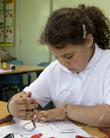 Young girl bending wire with pliers to make a steady hand game